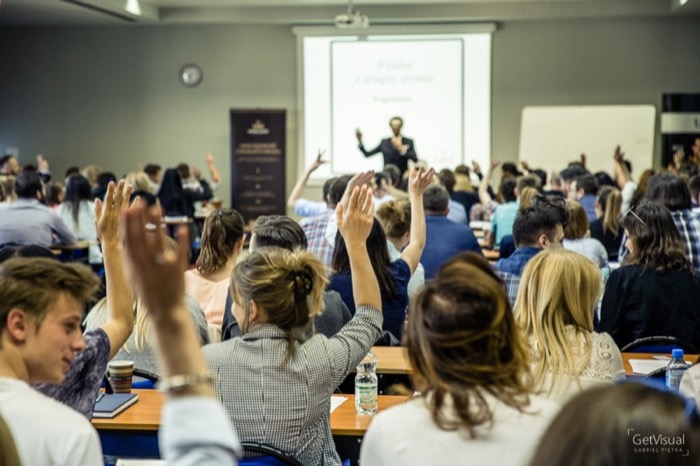 Publiczność na wykładzie z negocjacji — ręce w górze